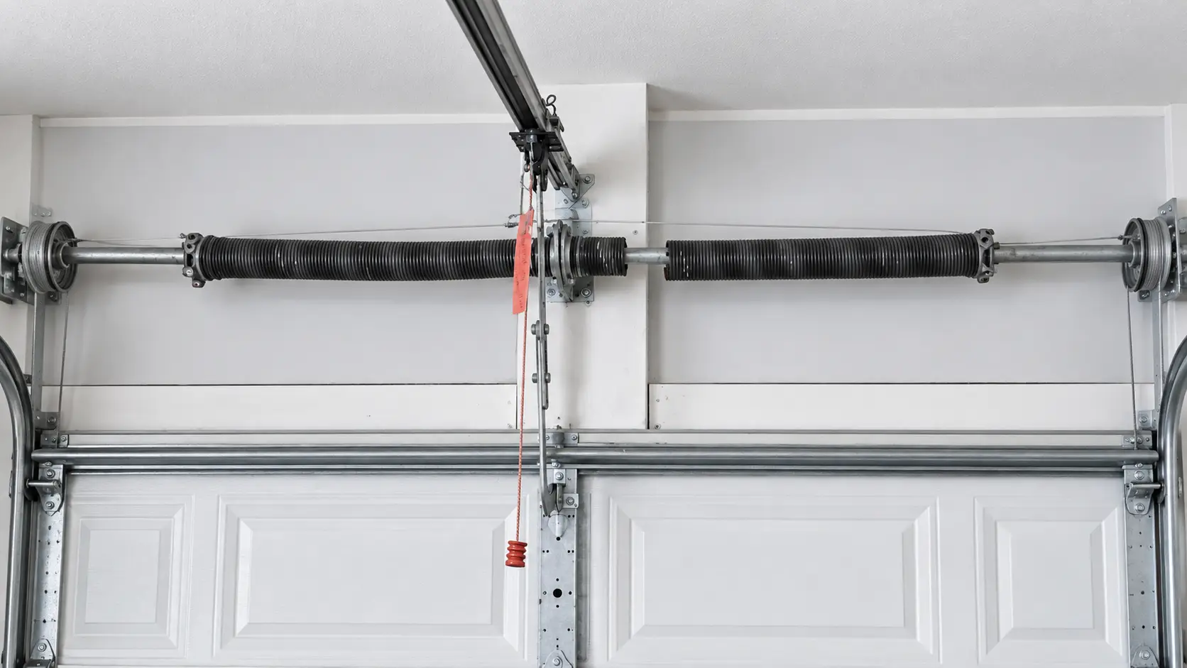 Broken garage door torsion spring and connected lifting hardware