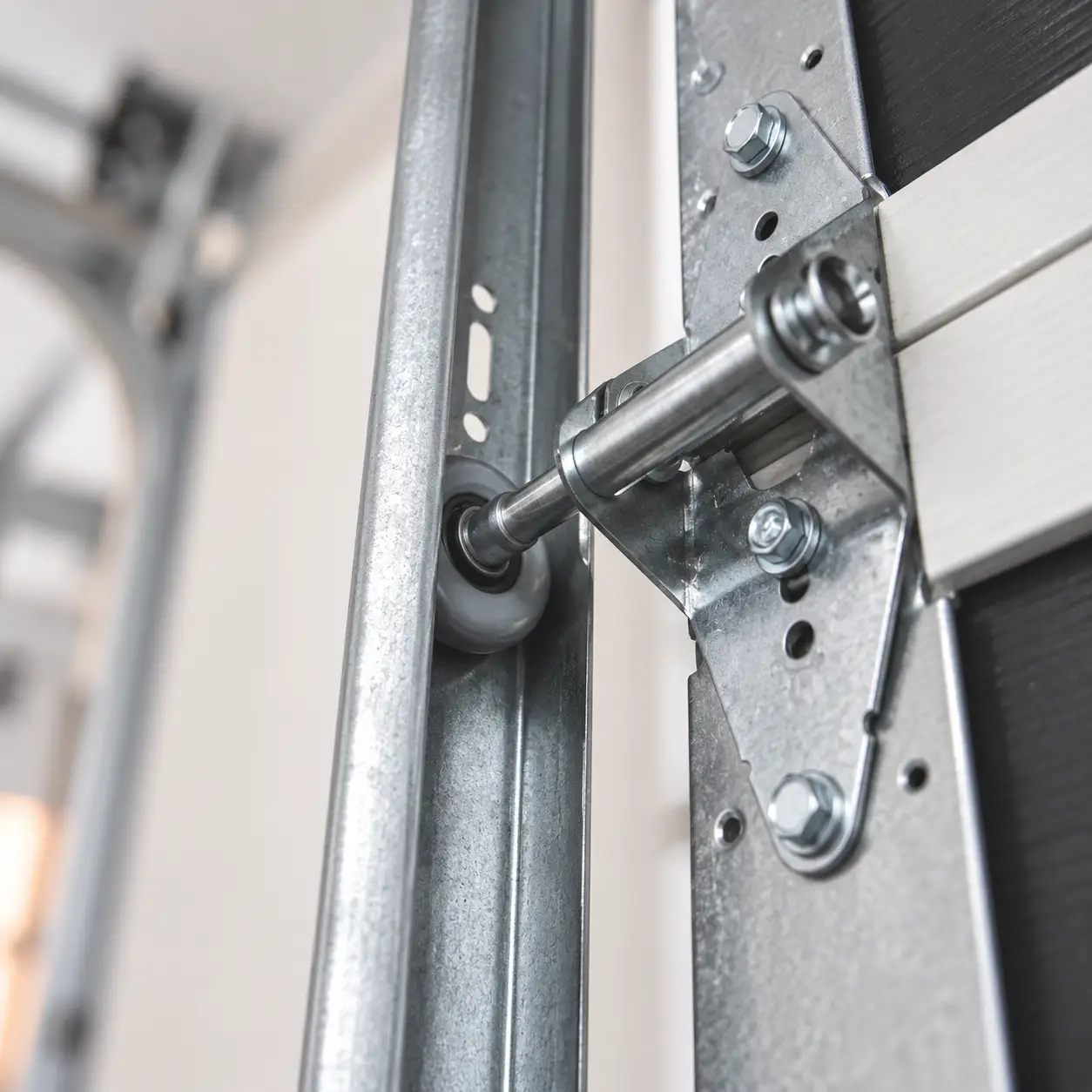Garage door hinge positions, shaft bearing, and track support brackets
