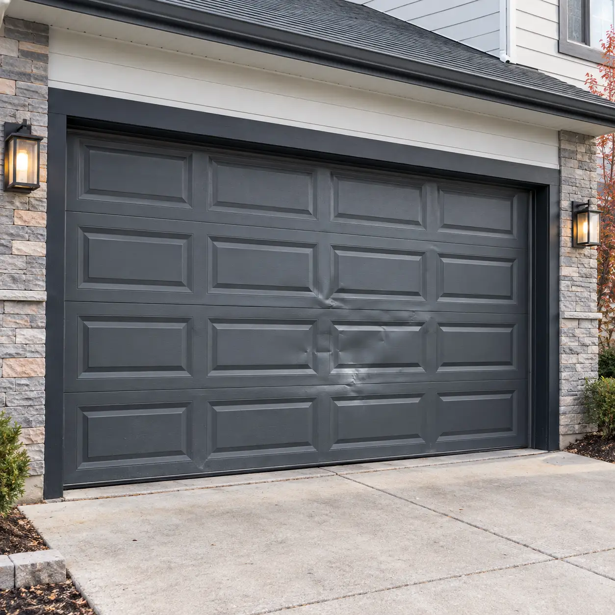Damaged residential garage door panel with dents and connected hinge hardware